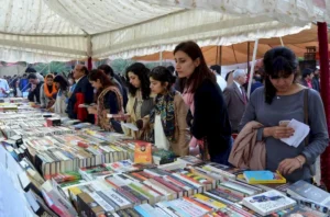 Readers selecting books during an annually held book fair reflecting modern shifts and urban society in eastern Pakistan.