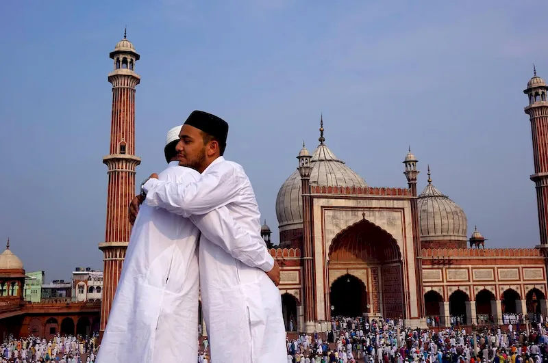 wo joyful Muslim men warmly hugging and smiling while celebrating Eid-ul-Fitr, the Islamic festival of love and joy.