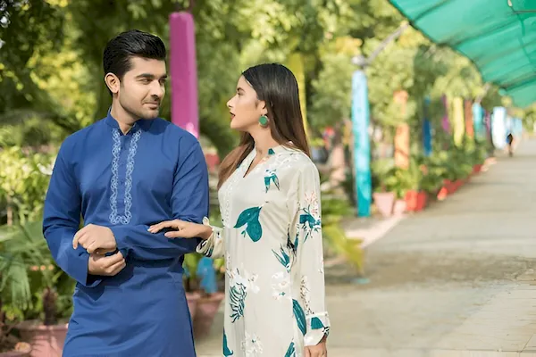 Young couple wearing traditional kurta kameez posing for a cultural portrait, showcasing Pakistani fashion and heritage.